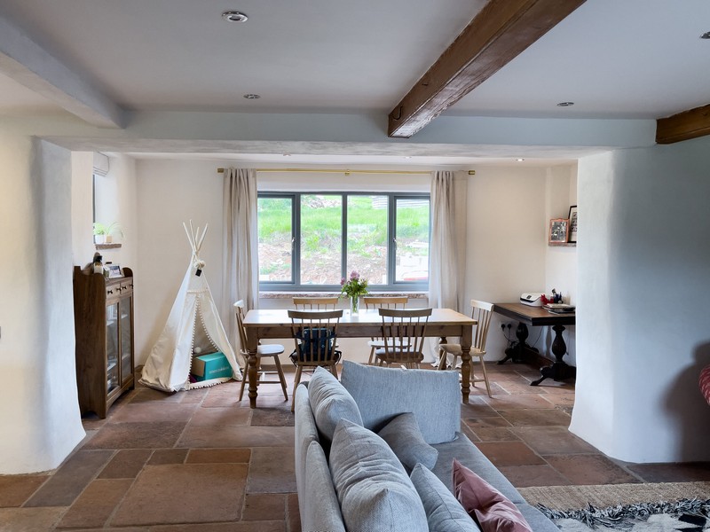 The interior of the living area with a dining table in a recess, tiled floor and finished diathonite and argatherm walls.