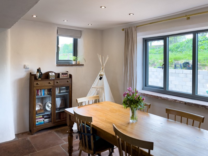 The interior of the living area with a dining table in a recess, tiled floor and finished diathonite and argatherm walls