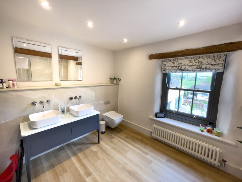 The finished bathroom featuring twin sinks and mirrors. The walls are finished with diathonite and argatherm